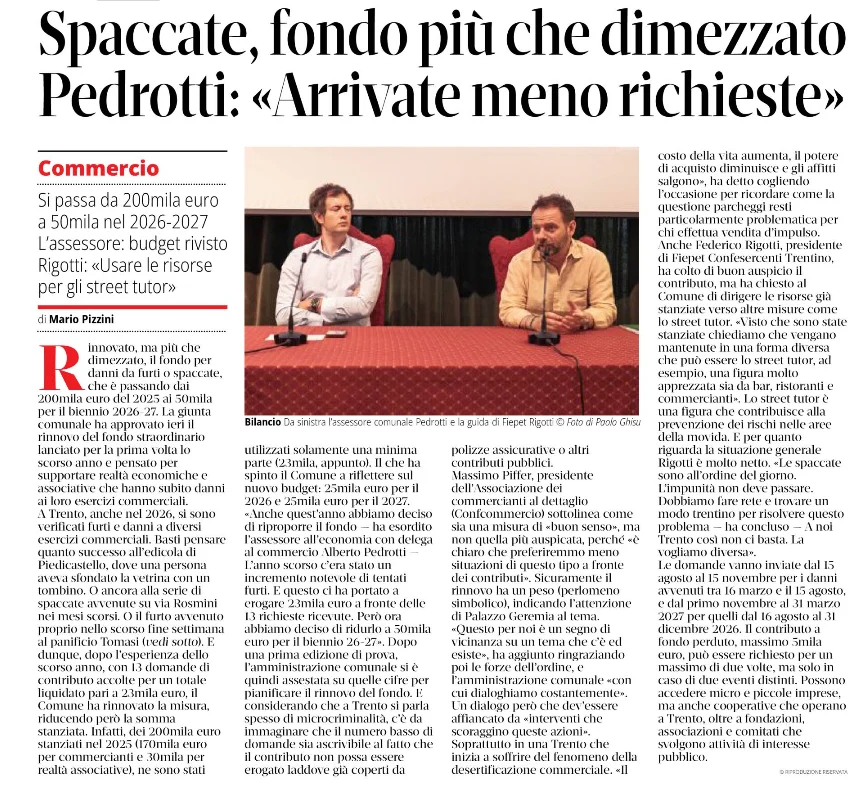 Una pagina di giornale mostra un titolo grande, un articolo e una fotografia di due uomini seduti a un tavolo.