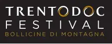 Limmagine mostra un logo su sfondo nero con le parole TRENTODOC FESTIVAL in bianco, le O di TRENTODOC decorate con anelli dorati, e la frase BOLLICINE DI MONTAGNA in oro. Limmagine mostra un logo su sfondo nero con le parole TRENTODOC FESTIVAL in bianco, le O di TRENTODOC decorate con anelli dorati, e la frase BOLLICINE DI MONTAGNA in oro.