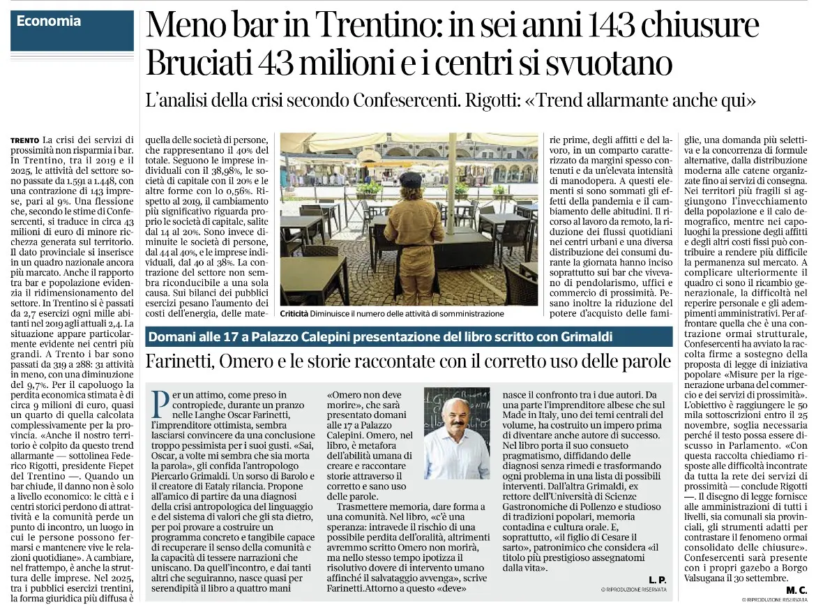 Limmagine raffigura unarea di ristorazione allaperto con molti tavoli e sedie in gran parte vuoti, una persona in uniforme in piedi al centro e edifici in stile urbano sullo sfondo.