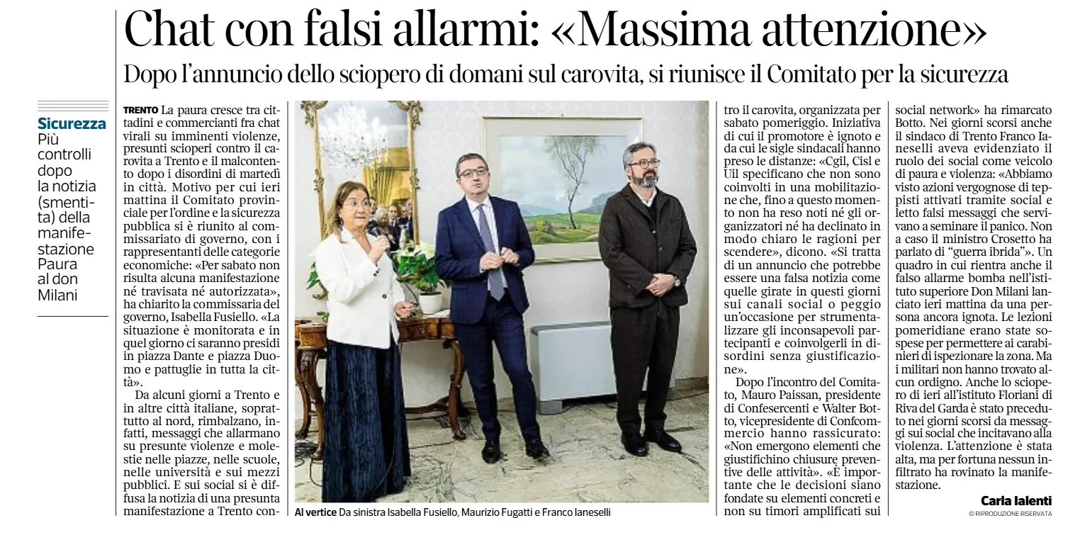 La pagina di un giornale include unimmagine che raffigura tre persone in una stanza, con una donna che parla al microfono affiancata da due uomini.